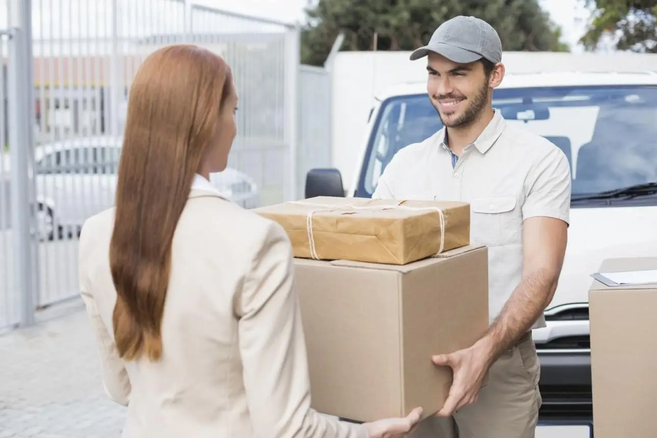 Delivery handover — driver and recipient exchanging packages at stop; service time is measured from check-in to check-out